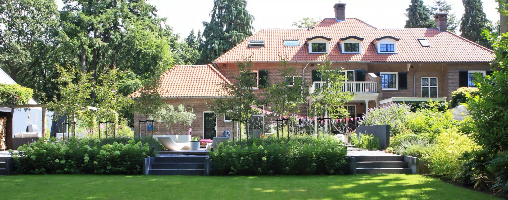 Panoramisch zicht op villatuin met verhoogde terrassen en klassieke Nederlandse villa