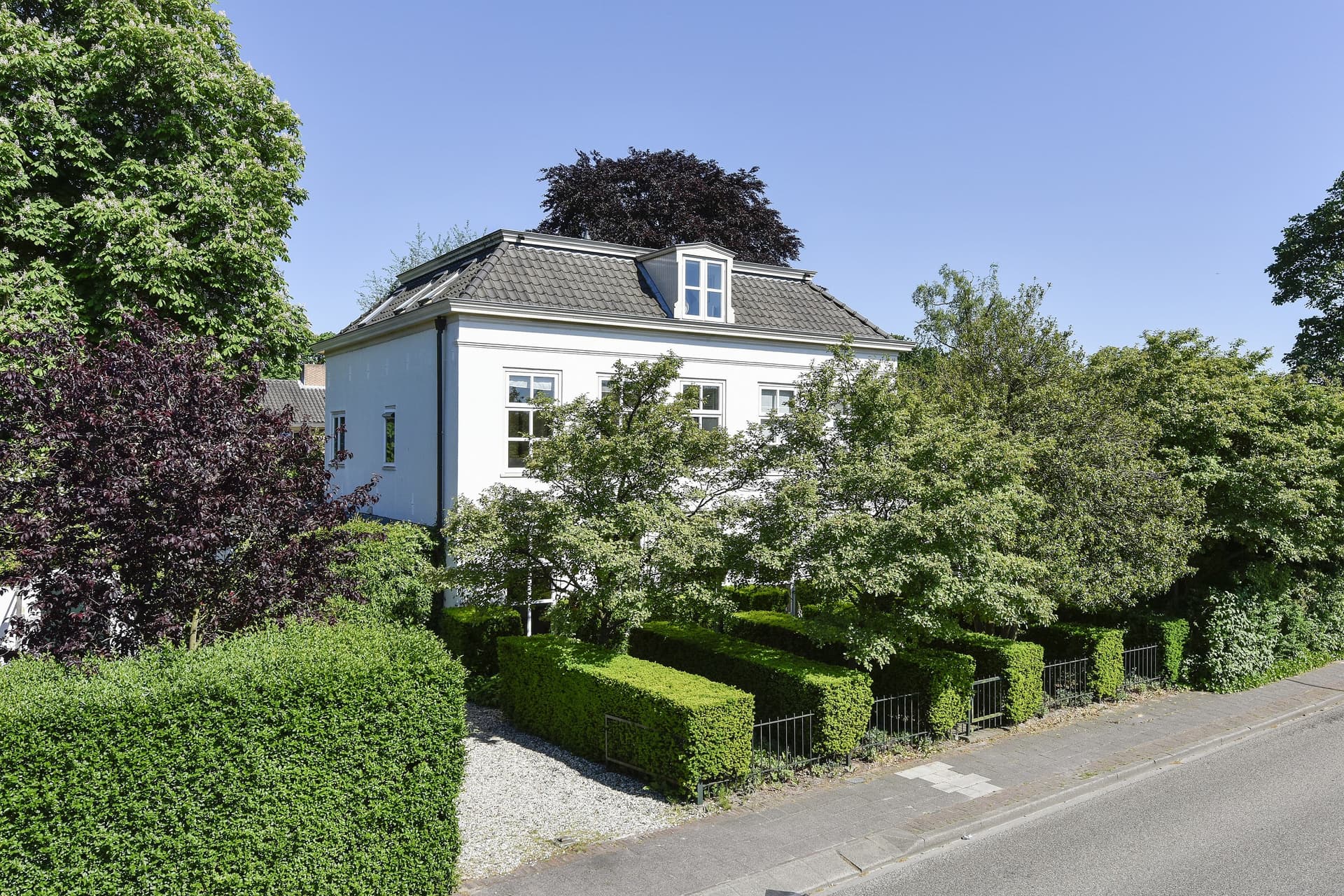 Oude pastorie in Hoogland met vormgesnoeide hagen en zichtbare architectuur