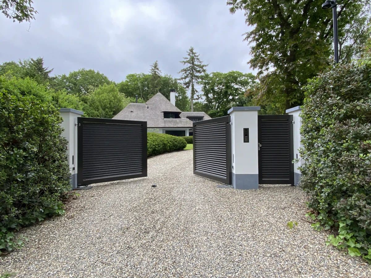 Moderne entree met zwarte lamellen en witte zuilen