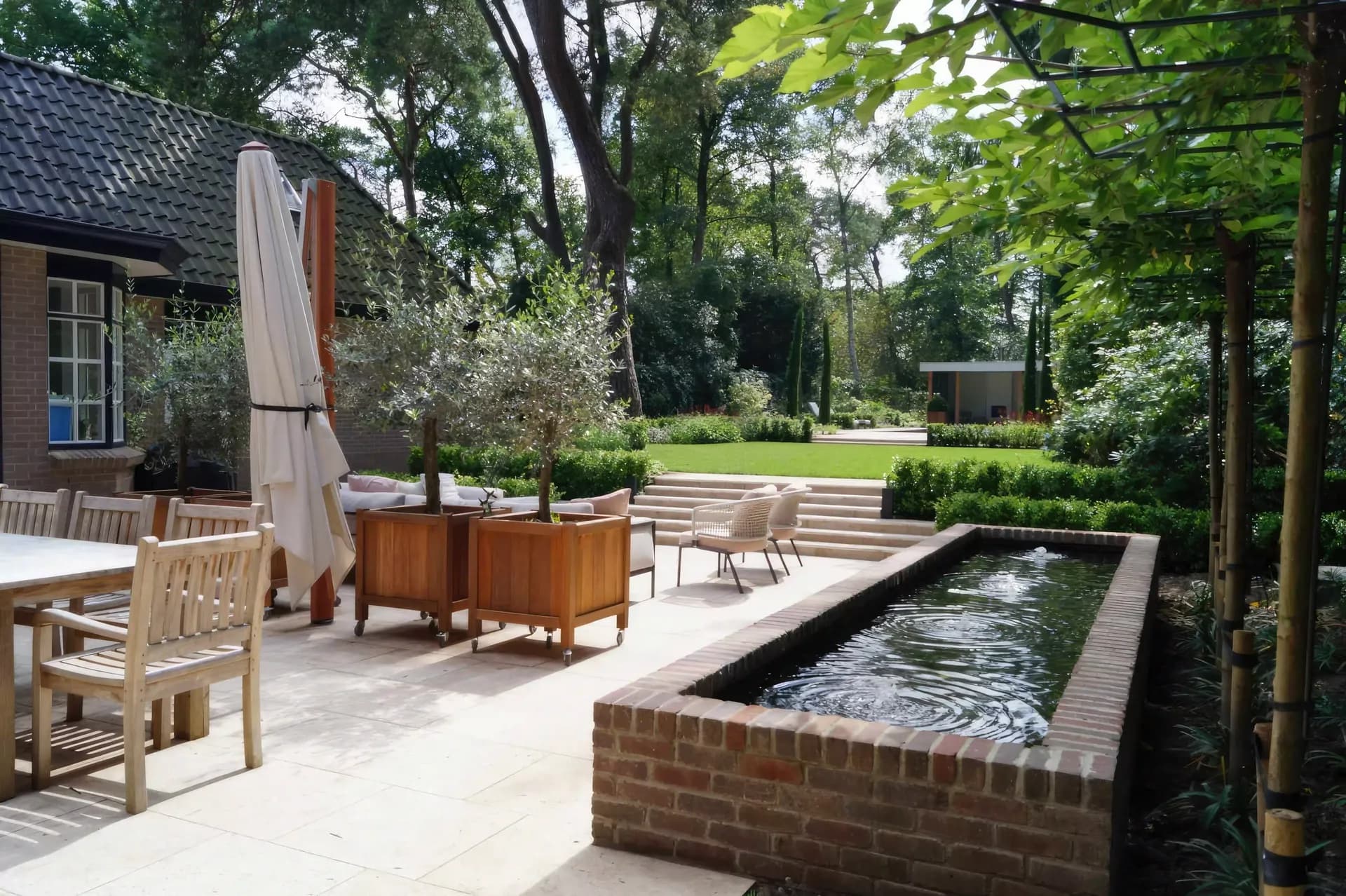 Sophisticated terrace with raised water feature and wooden planters