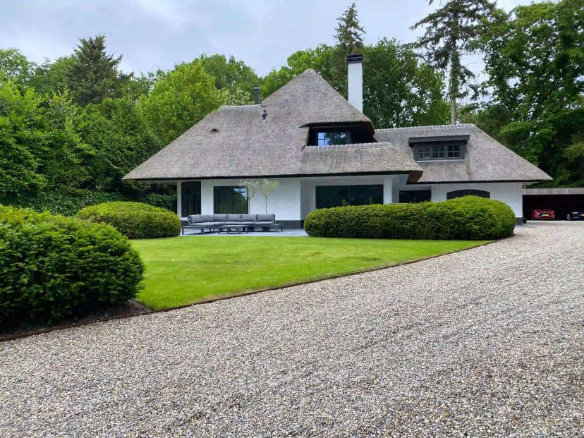Minimalistische Gooische tuin met royale Schellevis tegels en grindoprit
