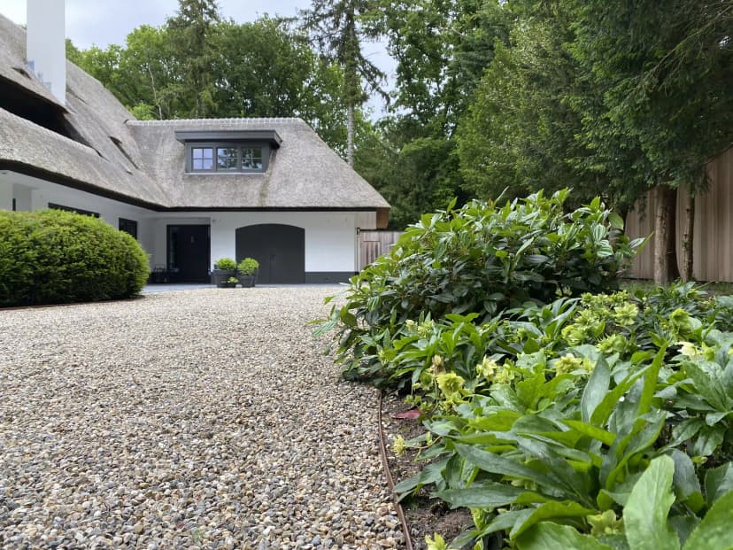 Thatched garage of bijgebouw met witte muren en zwarte deuren