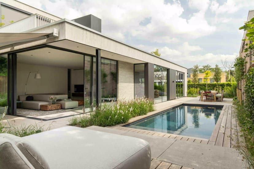 Modern garden with sleek swimming pool, outdoor seating, and glass doors