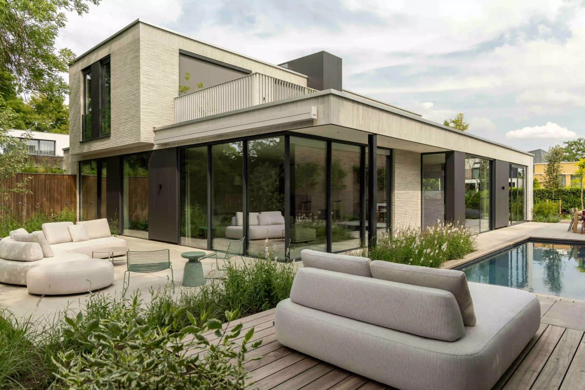 Wide view of modern house with pool and outdoor lounge furniture