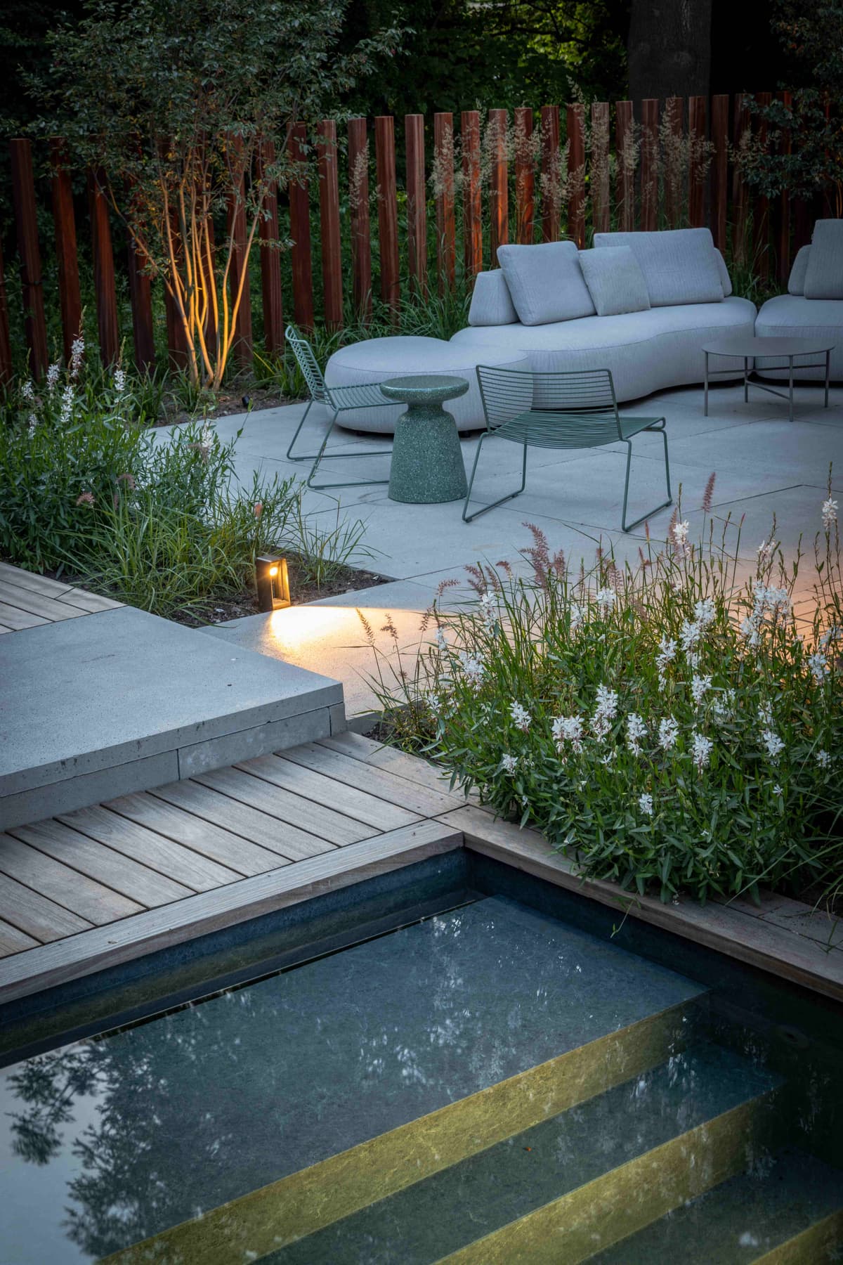 Evening lounge area with uplighting and white flowering plants
