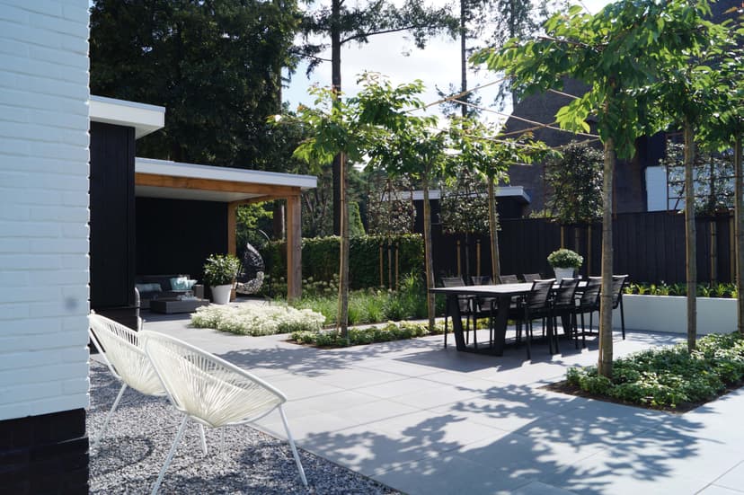 Overdekt terras met loungeplek, houten pergola en moderne witte stoelen