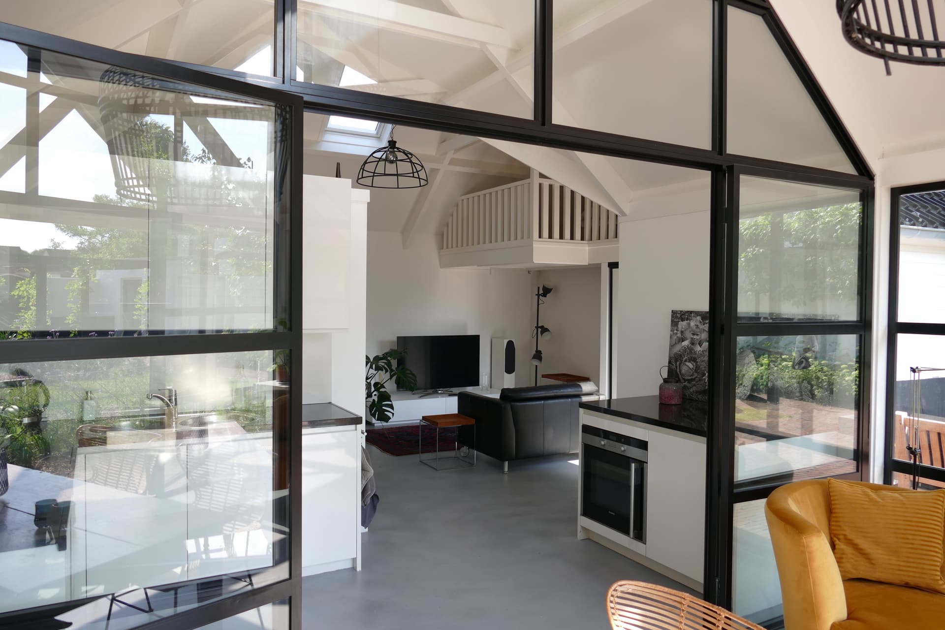 Overzicht met mezzanine, keuken en industriƫle raampartijen