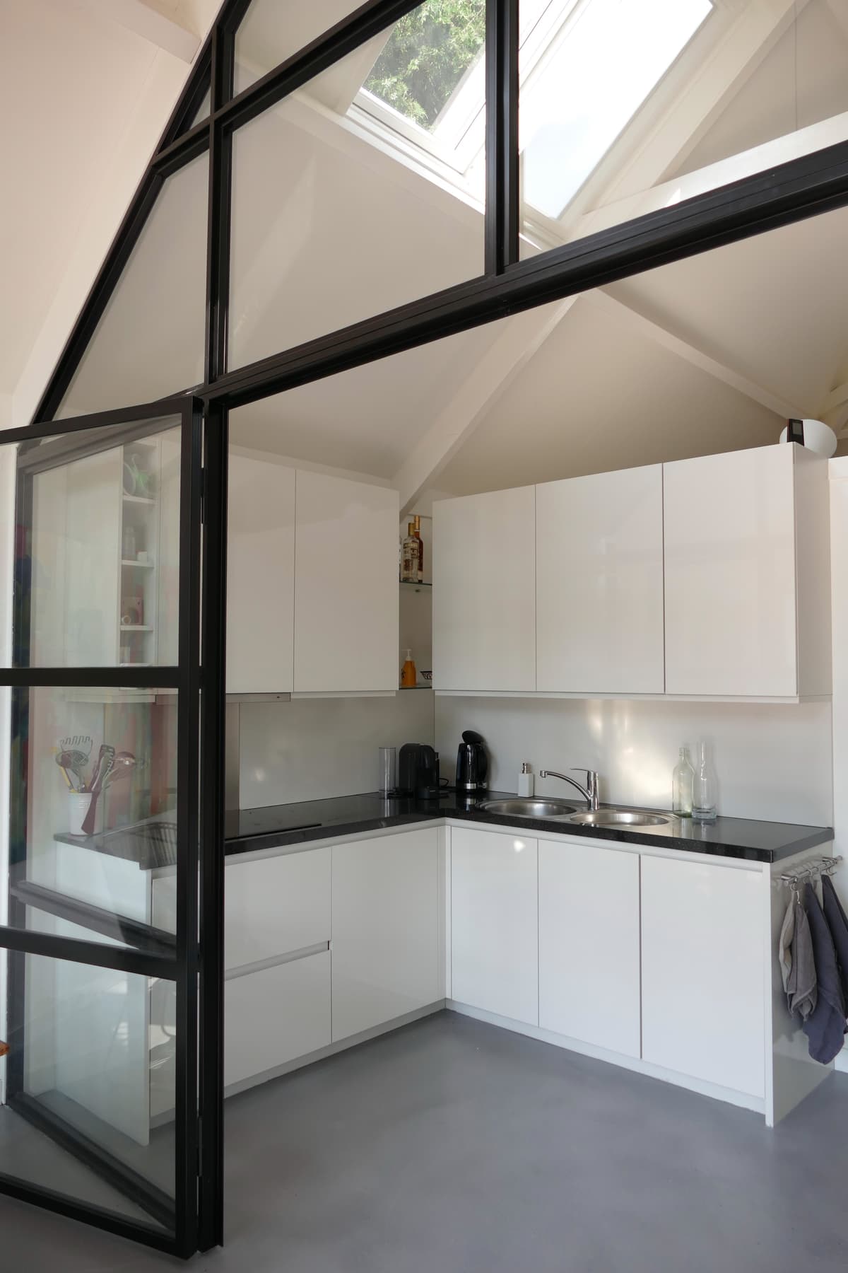 Moderne witte keuken met zwarte werkbladen en dakramen