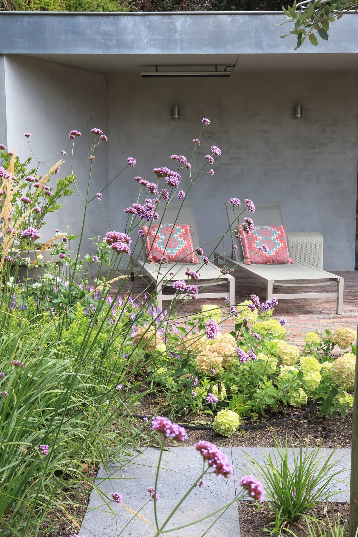 Overdekt loungeterras met moderne stoelen en verwarmingselement