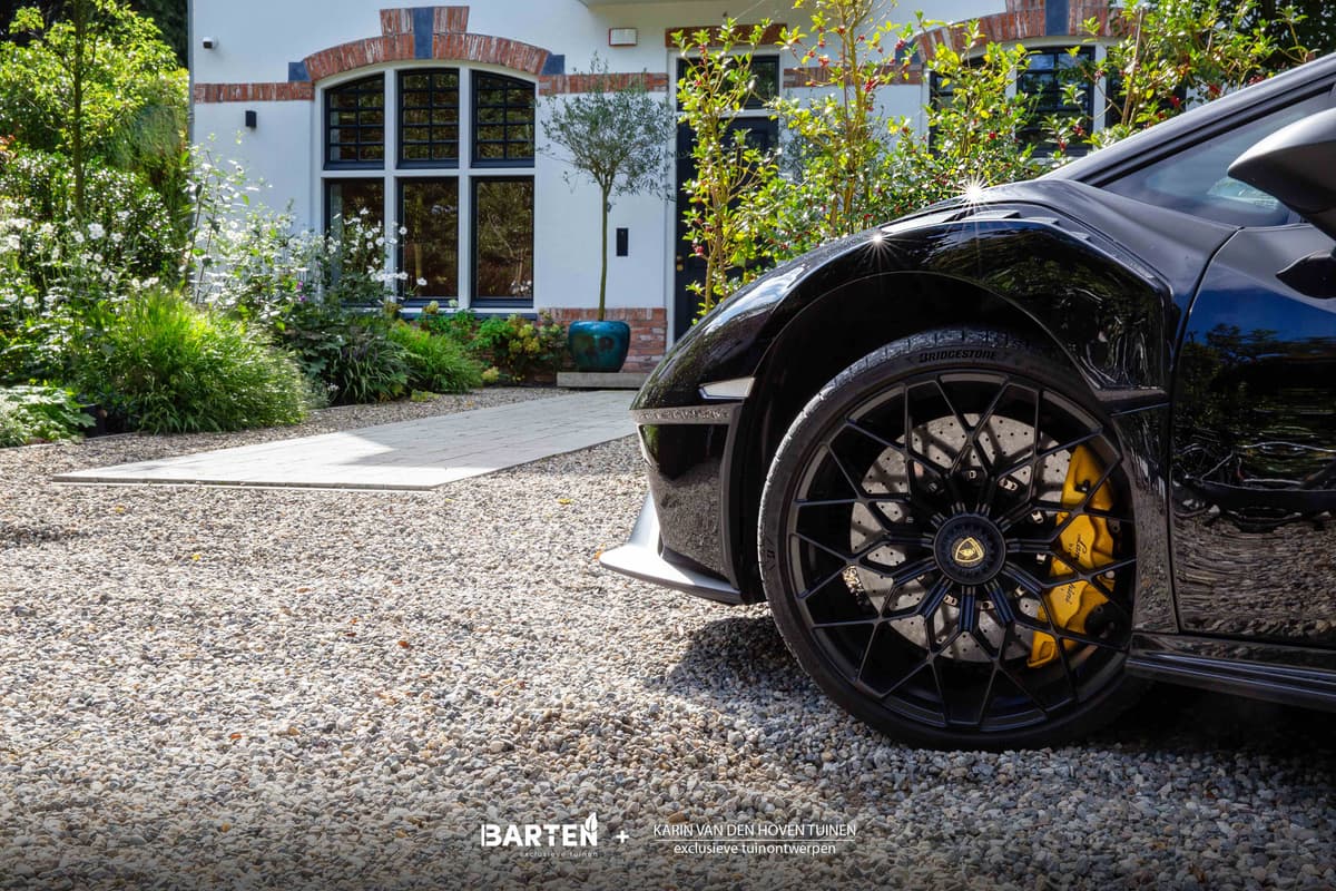 Grindoprit met luxe sportwagen en mediterrane entree met olijfboom