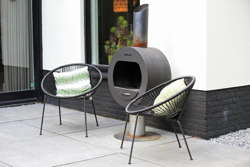 Moderne buitenruimte met designstoelen en buitenhaard