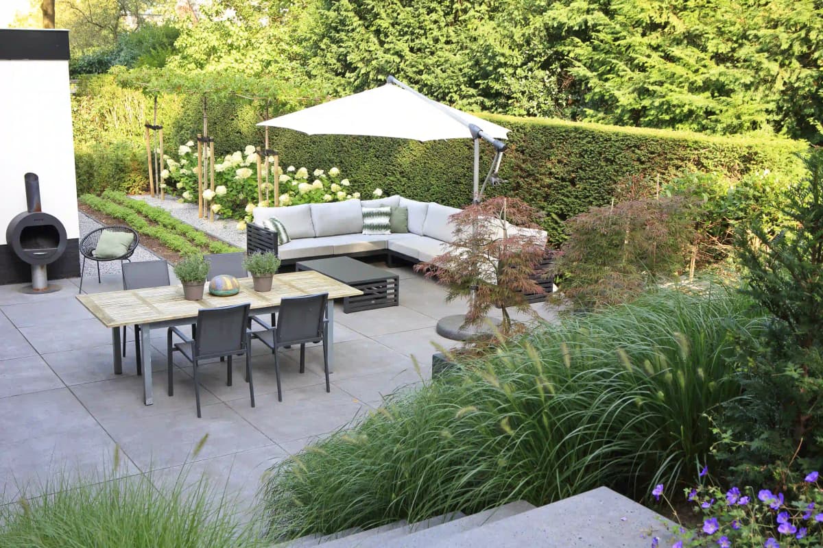 Ruim terras met moderne tuinmeubelen en parasol