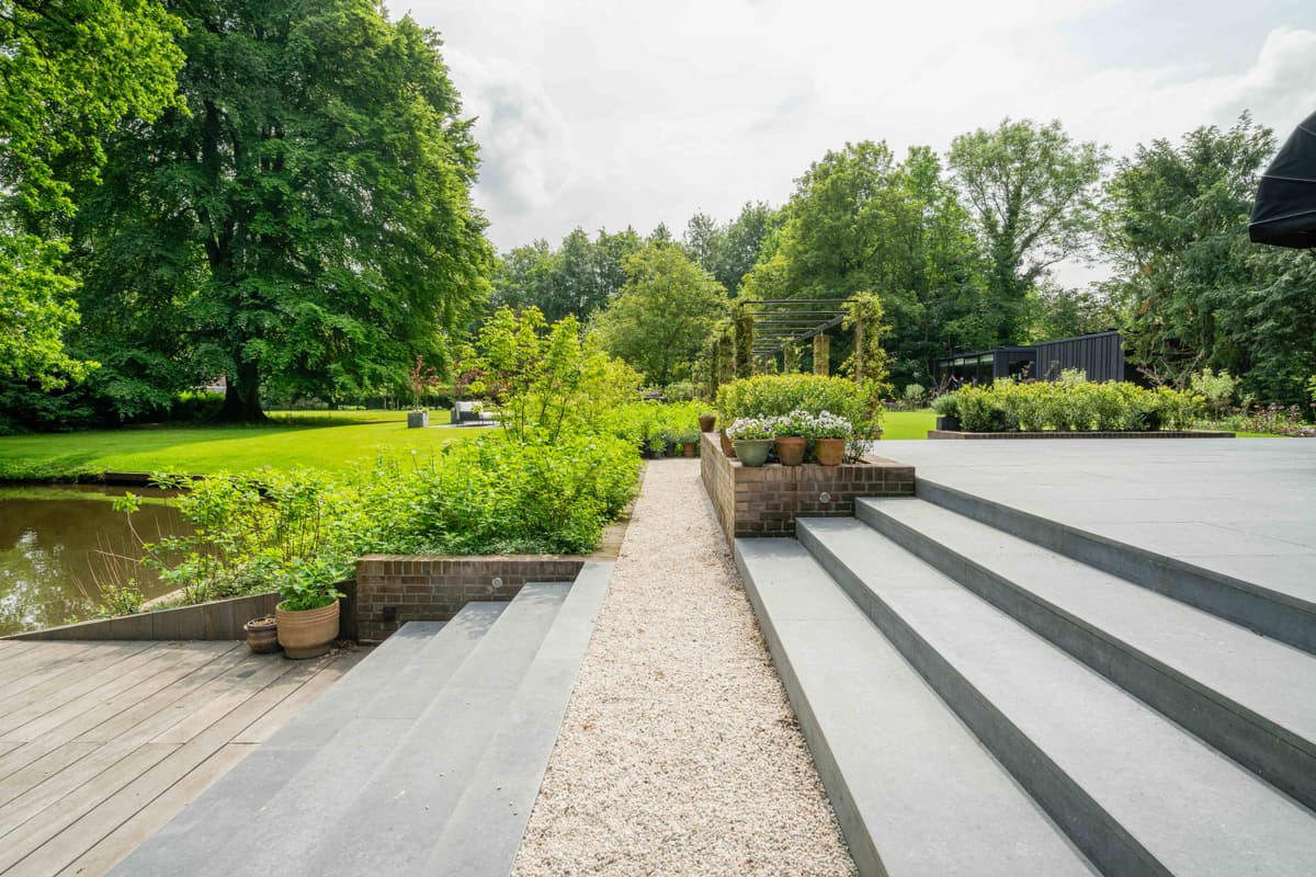 Getrapt stenen terras met waterpartij en tuinbeplanting