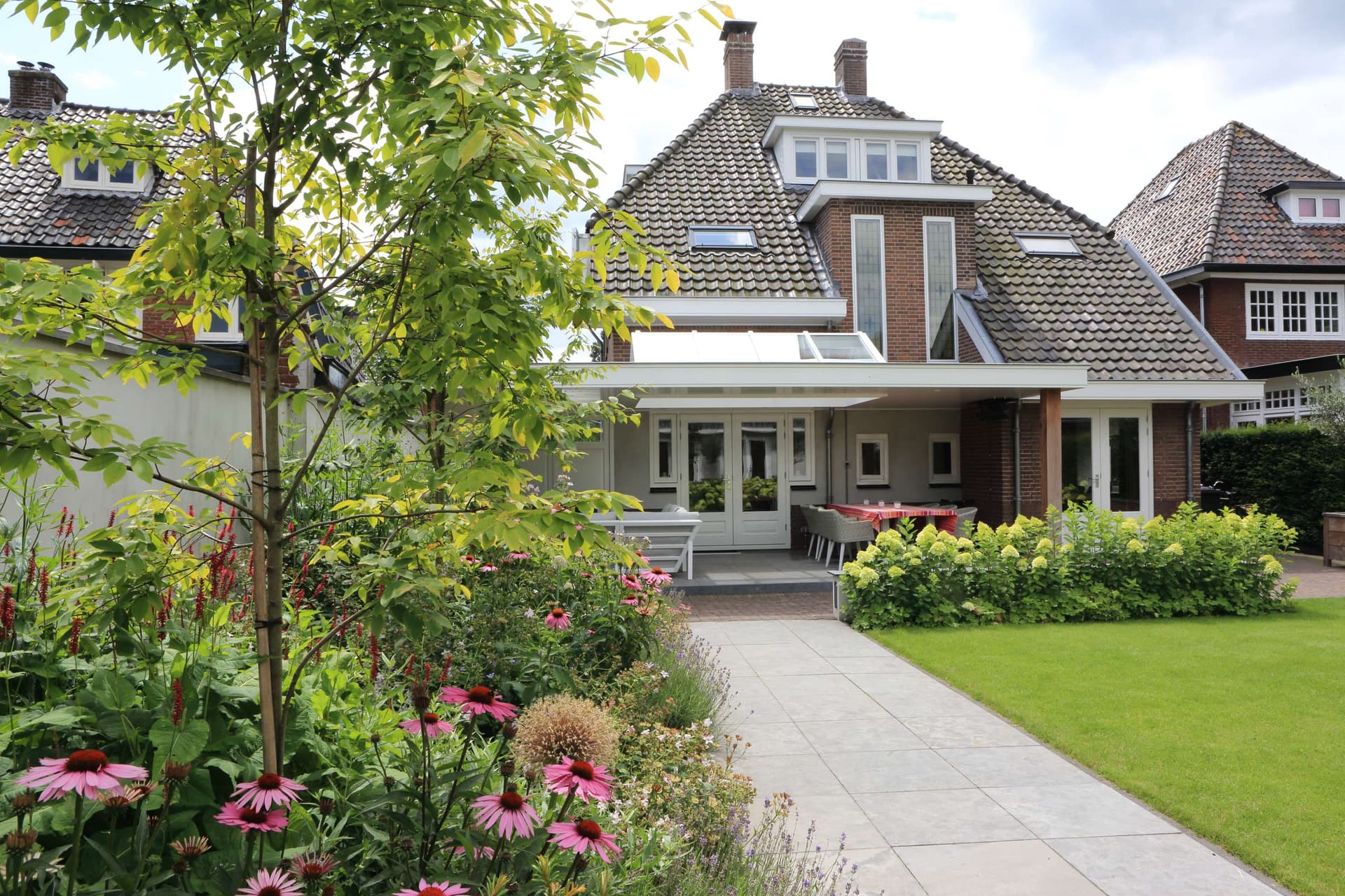 Familietuin met centraal gazon en royale veranda